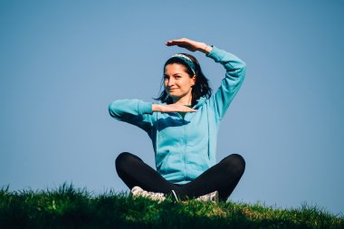 çimlerde oturan kadın gülümsüyor