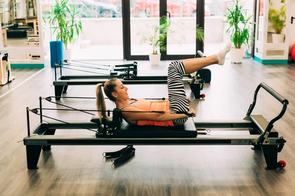 Kadın bir pilates reformer üzerinde