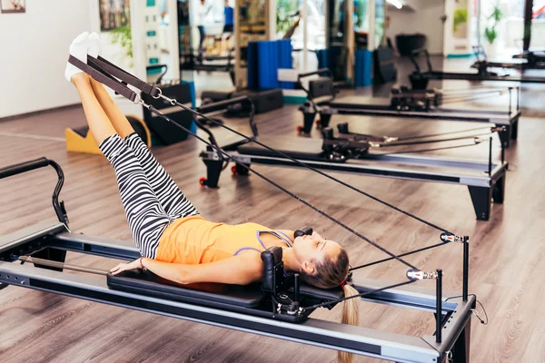 Vrouw die zich uitstrekt in een kamer van pilates — Stockfoto