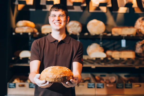 Salesman holding a bread — Stock Photo, Image