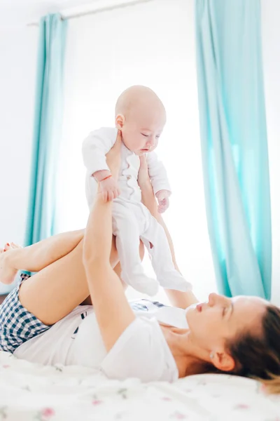 Mãe segurando bebê em joelhos — Fotografia de Stock
