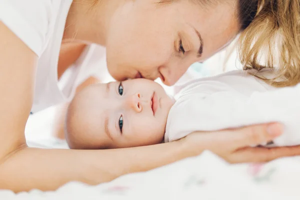 Mother kissing baby on cheek — Stock Photo, Image