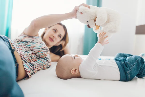 Madre y bebé jugando con oso de peluche —  Fotos de Stock