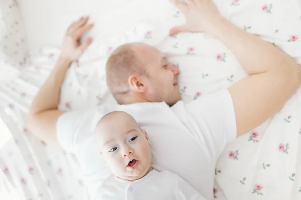Engraçado bebê deitado nas costas do pai — Fotografia de Stock