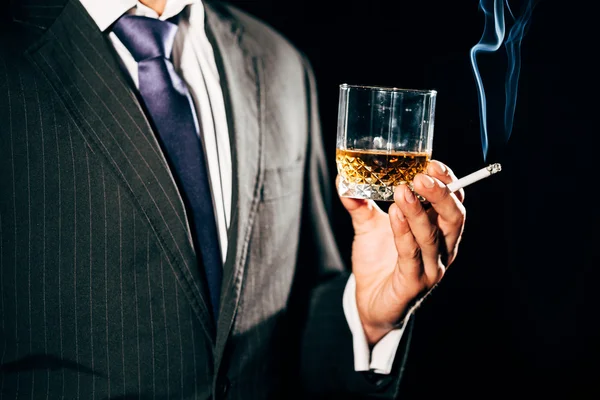 Hombre de traje con un vaso de whisky y un cigarrillo —  Fotos de Stock