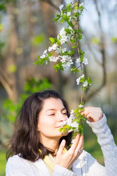 一个年轻而悠闲的女人身上散发着开花苹果枝条的香味 — 图库照片