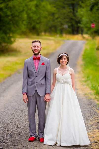 Noiva e noivo na estrada de cascalho — Fotografia de Stock
