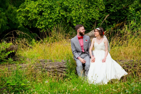 Braut und Bräutigam sitzen im Freien — Stockfoto