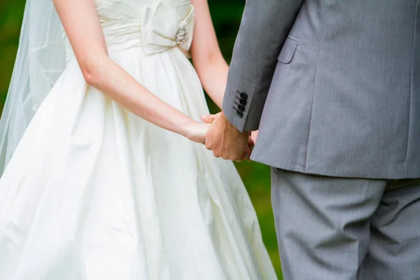 Bruid en bruidegom hand in hand bij ceremonie — Stockfoto