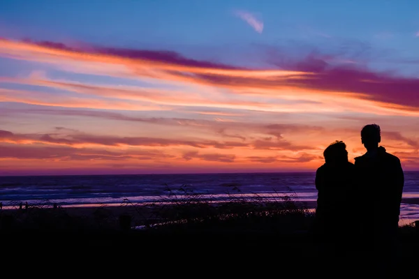 Casal ao pôr do sol na praia — Fotografia de Stock