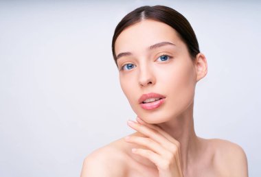 Cildine dokunan ve dudaklarını aralayan çekici bir kadının belden yukarı portresi. Boşluğu sol tarafa kopyala.