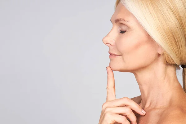 Profil, yan görüş, güzel çekici bir kadının yarım yüz portresi mükemmel bir boynu ve kapalı gözleri var. Masaj, iyileşme gri arka planda izole edilmiş. Boşluğu kopyala.