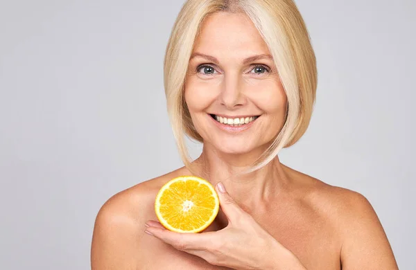 Smiling Woman Moisturized Skin Applying Cosmetics Vitamin Holding Half Orange — 스톡 사진