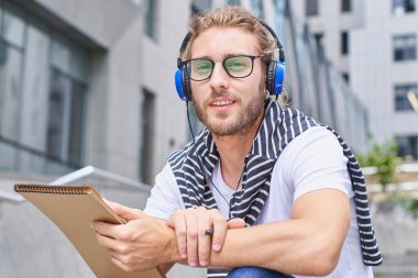 Boş zaman, eğitim ve insan konsepti - şehirde çizmek ya da çizmek için defteri, günlüğü ya da eskizi olan genç bir adam. Kentsel yaşam tarzı insanları.