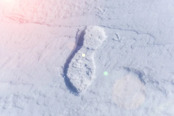 a human footprint from winter shoes in sunny weather on snow