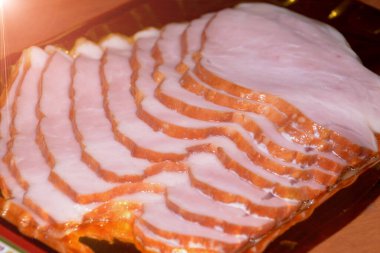 Tütsülenmiş ve kaynamış sosisi bir tabakta dilimlemek.