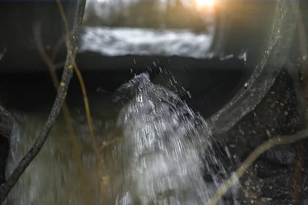 swirling streams of thawed spring water passing through drainage pipes