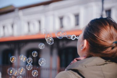 # Genç kız sokağın ortasında sabun köpüğü üflüyor #