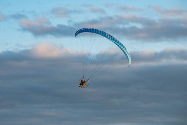 çok renkli bir paraglider, gökyüzünde bir motoru var.