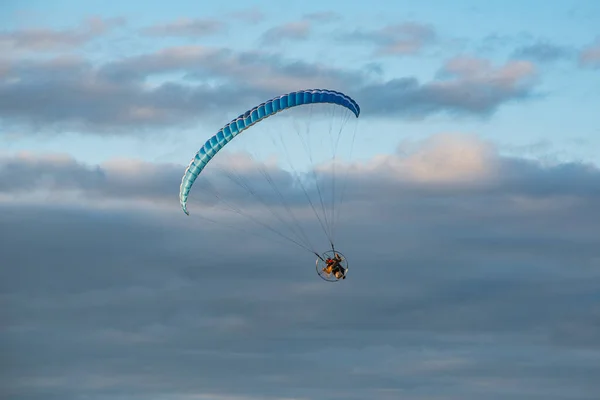 çok renkli bir paraglider, gökyüzünde bir motoru var.