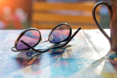 yuvarlak kadın güneş gözlükleri bir yaz kafesinde masanın üstünde.