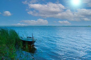 # Motorlu tekne kıyıya demirlemiş # # Göldeki çayırda #