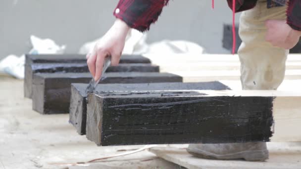 Liquid bitumen is applied to the wood beam. The process of applying liquid bitumen. — Stock Video