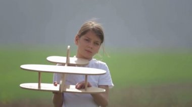 Bir model uçak ile oynayan beyaz çocuk. Bir alan ahşap bir düzlemde bir çocuk portresi. Çocuk doğada uçak düzeni ile çalış.