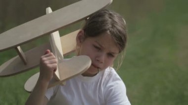 Bir model uçak ile oynayan beyaz çocuk. Bir alan ahşap bir düzlemde bir çocuk portresi. Çocuk doğada uçak düzeni ile çalış.