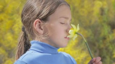 Bahar bir çocuk portre sarı nergis çiçek ile. Kendini beğenmiş çocuk çiçeği nergis kokulu. Çocuğun yüzü genç onun elinde bir çiçek ile.