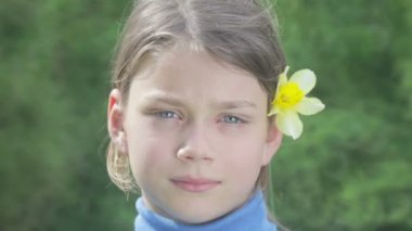 Bahar bir çocuk portre sarı nergis çiçek ile. Kendini beğenmiş çocuk çiçeği nergis kokulu. Çocuğun yüzü genç onun elinde bir çiçek ile.