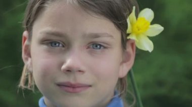 Bahar bir çocuk portre sarı nergis çiçek ile. Kendini beğenmiş çocuk çiçeği nergis kokulu. Çocuğun yüzü genç onun elinde bir çiçek ile.