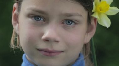 Bahar bir çocuk portre sarı nergis çiçek ile. Kendini beğenmiş çocuk çiçeği nergis kokulu. Çocuğun yüzü genç onun elinde bir çiçek ile.