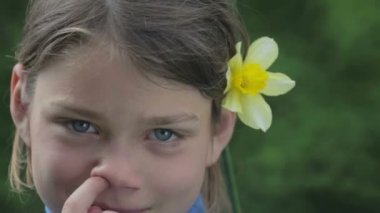 Bahar bir çocuk portre sarı nergis çiçek ile. Kendini beğenmiş çocuk çiçeği nergis kokulu. Çocuğun yüzü genç onun elinde bir çiçek ile.