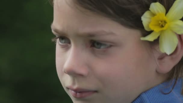 Portrét chlapce na jaře s květ žlutého narcisu. Ješitný chlapec vonící květ narcisu. Chlapcova tvář dospívající s kytkou v ruce. — Stock video