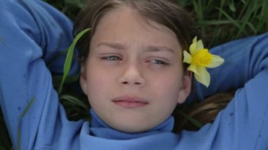 Bahar bir çocuk portre sarı nergis çiçek ile. Kendini beğenmiş çocuk çiçeği nergis kokulu. Çocuğun yüzü genç onun elinde bir çiçek ile.