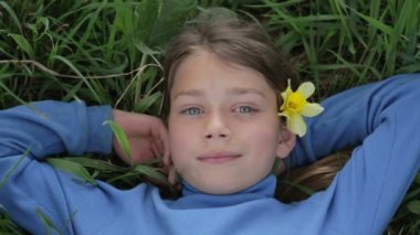 Bahar bir çocuk portre sarı nergis çiçek ile. Kendini beğenmiş çocuk çiçeği nergis kokulu. Çocuğun yüzü genç onun elinde bir çiçek ile.