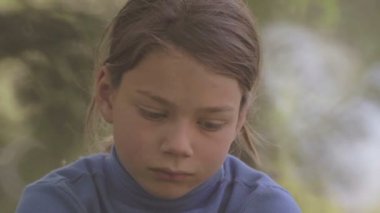 Üzgün çocuk kameraya benziyor. Kameraya bakarak üzgün çocuk portresi. Çocuk arıyorsunuz kamera sonra gülümsüyor pişmanlık ile. Yüzünü kapat. 