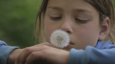 Bir çiçek karahindiba ile bir çocuk portresi. Yüz yakın çekim çocuk karahindiba ile. Duygusal bir Avrupa genç bir çiçek karahindiba ile portresi.