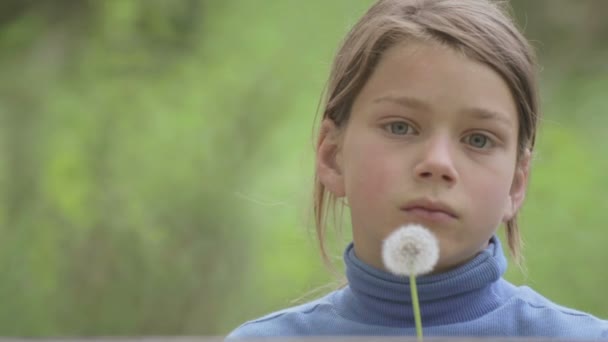 Ritratto di padre e figlio con un dente di leone di fiori. Il padre barbuto che gioca con suo figlio. L'uomo barbuto con un bambino che soffia su un dente di leone . — Video Stock