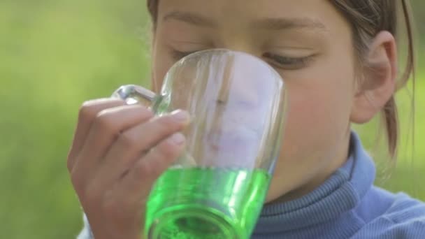 Ragazzo che beve acqua zuccherata. Il bambino beve frutta bevanda verde. Ritratto di un ragazzo dalla pelle bianca con limonata . — Video Stock