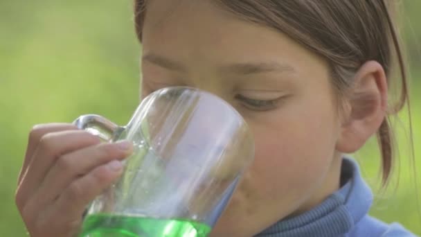 Chlapec pitnou vodu s cukrem. Dítě pije zelený nápoj. Podobizna chlapce bílé pleti s limonádou. — Stock video