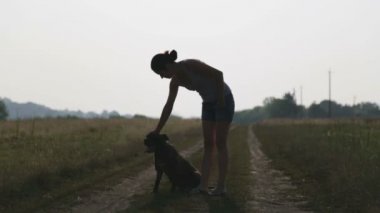 Genç kadın ile köpek doğada. Kız a korkunç bir alanda yürüyüş. Şehir dışında bir köpek ile yürüme. 