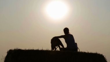 Bir köpek inç yemlik genç bir kızla silüeti. Korkunç bir alanda gün batımında kadınla. 