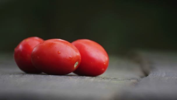 De samenstelling van rode tomaten op tafel. Rijpe tomaten op de houten achtergrond. — Stockvideo