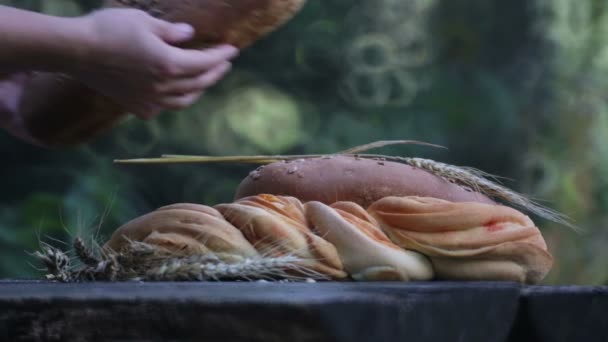テーブルの上の焼きたてのパン。手は、外のテーブルでパンを置く. — ストック動画