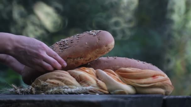 Pane fresco sul tavolo. Mano mette il pane sul tavolo fuori . — Video Stock