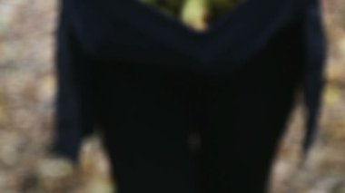 Genç bir kadın ormanda yürüyüş için ceketinde mantar topluyor.. 