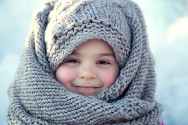 Kışın başörtüsü takan küçük bir kızın portresi.