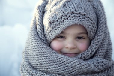 Kışın başörtüsü takan küçük bir kızın portresi.